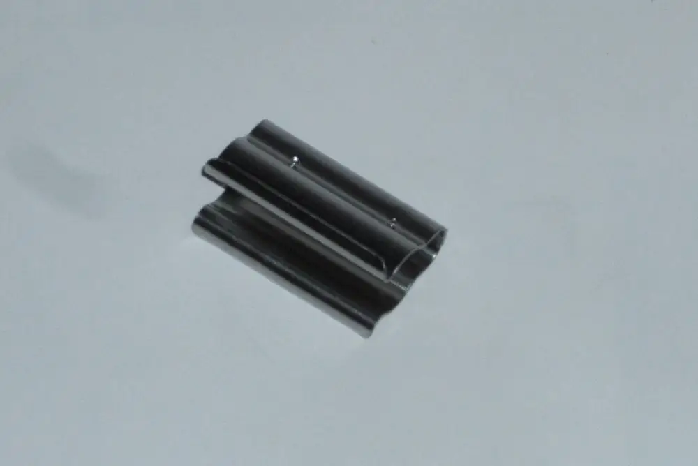 Schwarzes Metallteil mit zwei parallel verlaufenden Einkerbungen, möglicherweise zur Befestigung oder Montage, möglicherweise im Zusammenhang mit Daikin-Produkten.